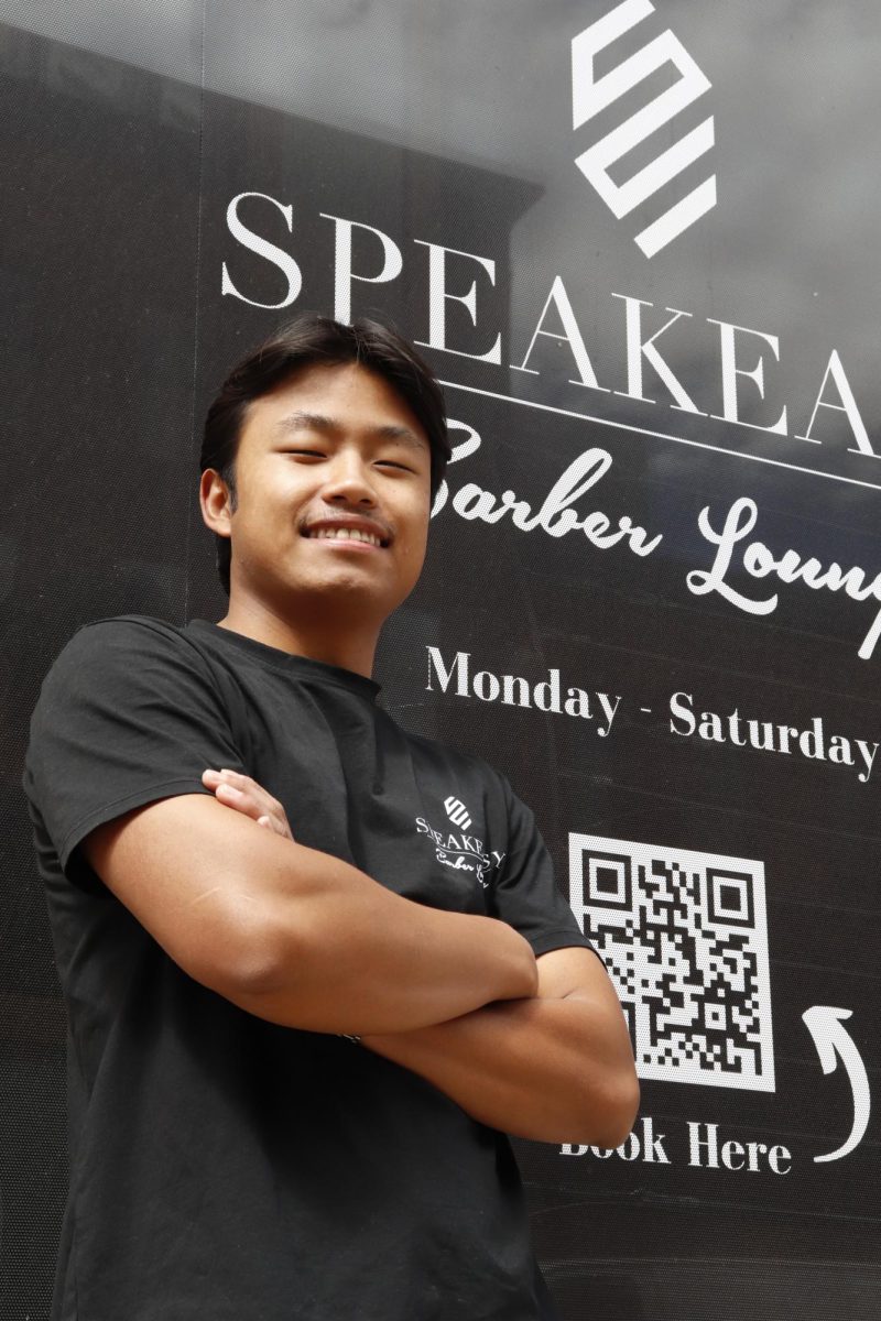 Van Cung poses in front of the Speakeasy Barber Lounge