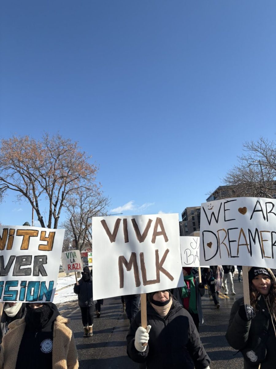 Marchers seen with various signs celebrating the life of Martin Luther King Jr. 
