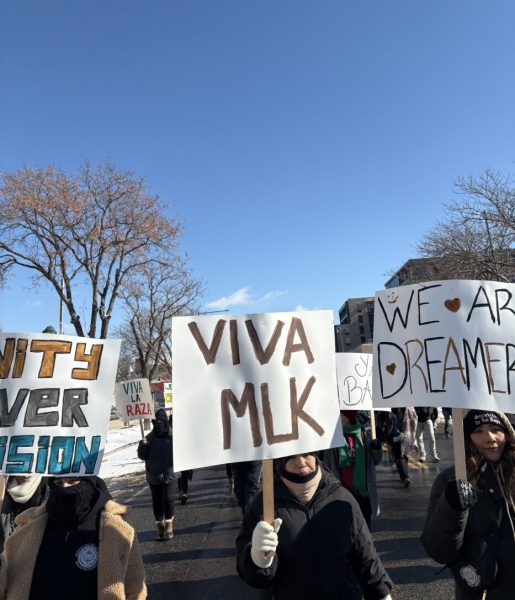 Marchers seen with various signs celebrating the life of Martin Luther King Jr. 
