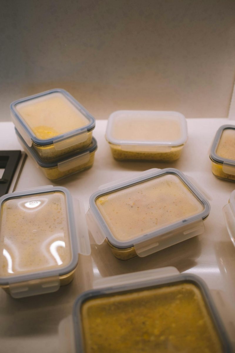 A variety of tupperware containers with soup inside on a white table